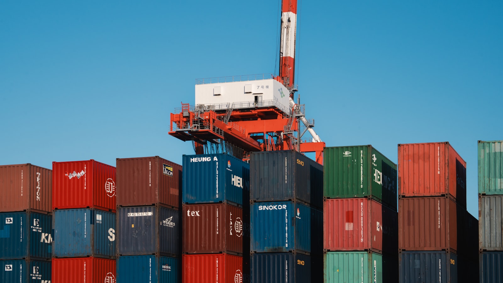 Macara de terminal deasupra unei stive de containere de marfă