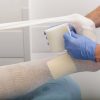 Cadru medical care aplică un bandaj pe piciorul unui pacient
