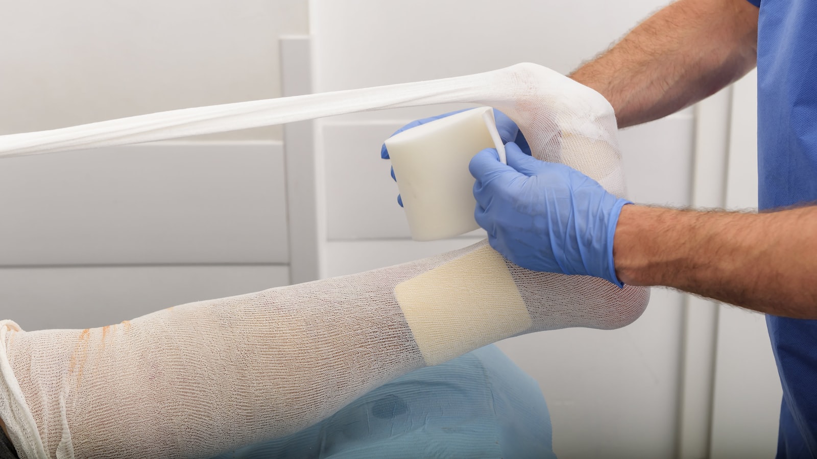 Cadru medical care aplică un bandaj pe piciorul unui pacient
