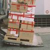 Palet cu colete de carton legate cu bandă, la rampa de încărcare a unui camion